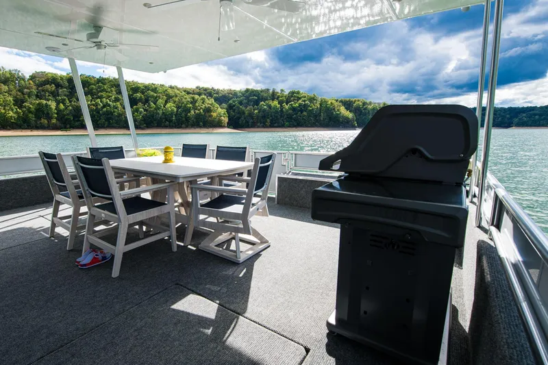 Slide: The Image of Outdoor dining area on 2026 Sumerset Luxe II houseboat with scenic lake view. - 37