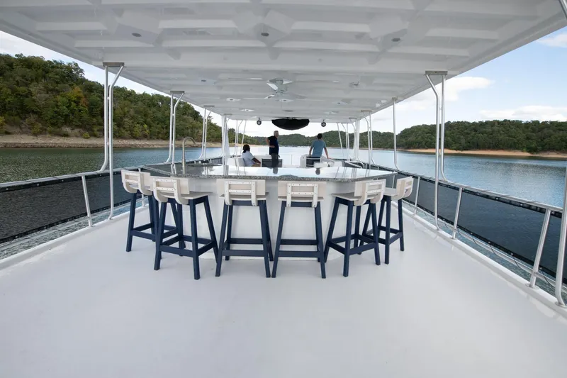 Slide: The Image of Luxurious Sumerset Luxe II 2026 houseboat with spacious deck and bar, cruising on a serene lake. - 44