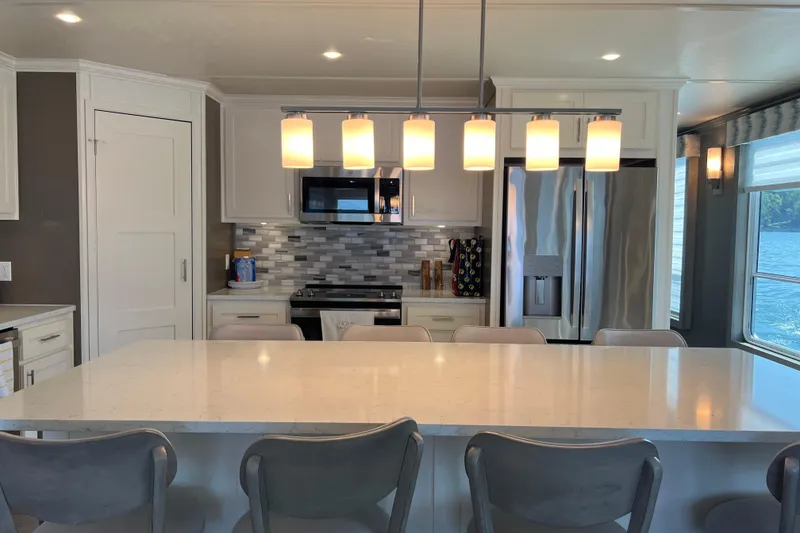 Slide: The Image of Modern kitchen in 2026 Sumerset Luxe II houseboat with island, pendant lights, and stainless steel appliances. - 6