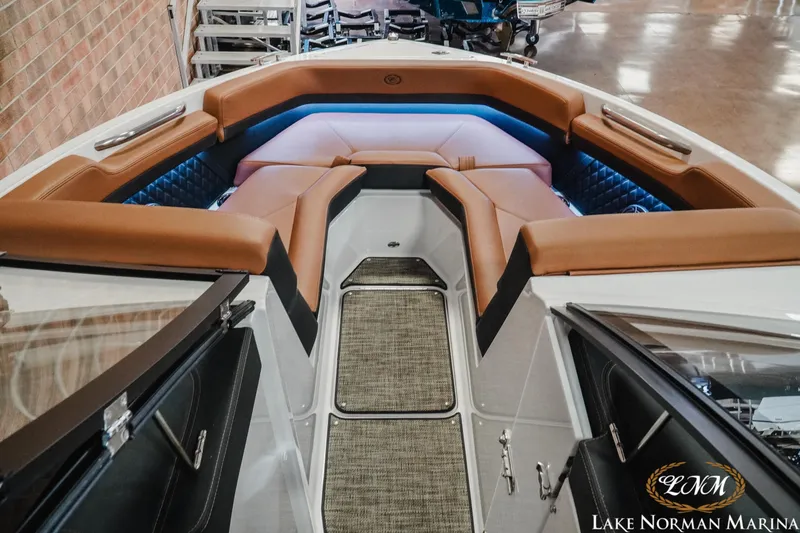 Slide: The Image of 2025 Cobalt R4 boat interior with tan seating and ambient lighting at Lake Norman Marina. - 14
