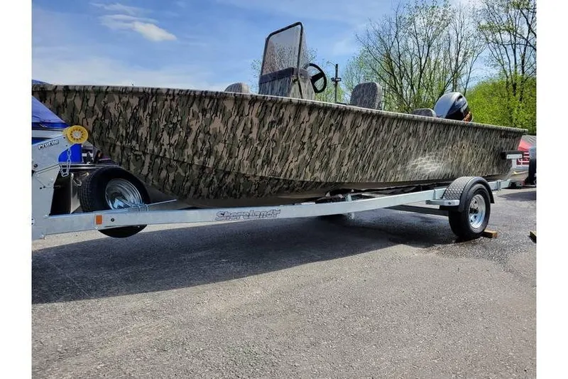 Slide: The Image of 2026 Smoker Craft Freedom 180 CC boat with camouflage design on a trailer. - 2