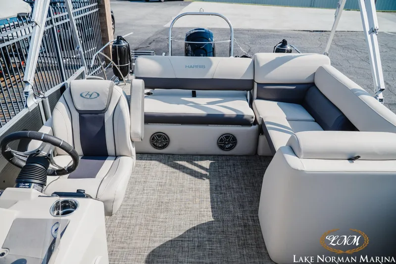 Slide: The Image of 2023 Harris Cruiser 210 pontoon boat interior with plush seating and steering console. - 13