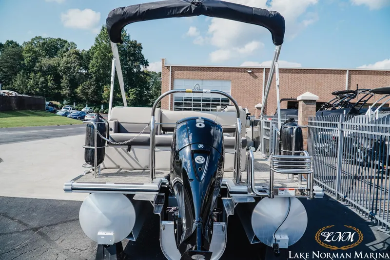 Slide: The Image of 2023 Harris Cruiser 210 pontoon boat at Lake Norman Marina, featuring a powerful outboard motor. - 4