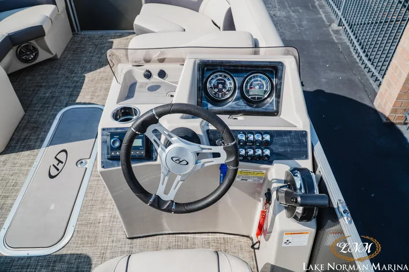 Slide: The Image of 2023 Harris Cruiser 210 boat dashboard with steering wheel and control panel. - 9