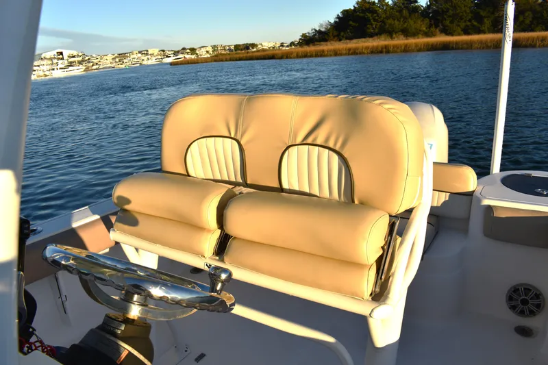 Slide: The Image of 2018 Sea Fox 226 Commander boat interior with beige seating and steering wheel on calm water. - 13