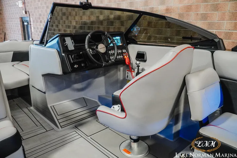 Slide: The Image of 2023 Moomba Max boat interior with modern dashboard and seating at Lake Norman Marina. - 11