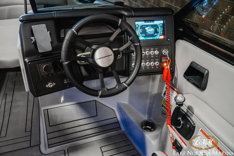 Slide: The Image of 2023 Moomba Max boat dashboard with steering wheel and control panel. - 12