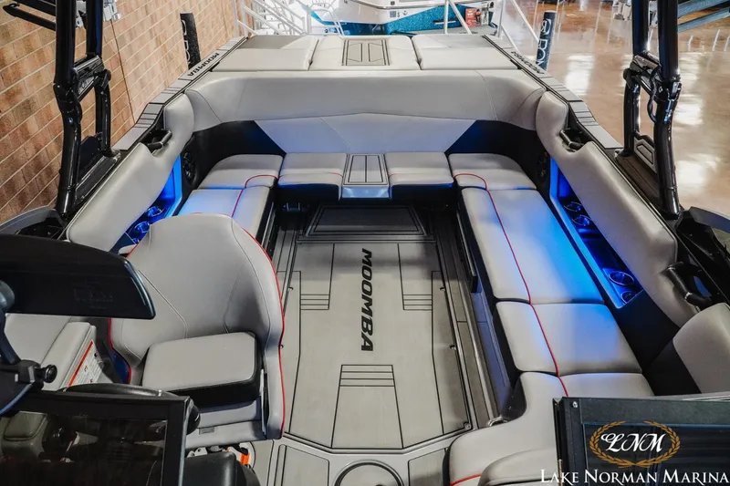 Slide: The Image of 2023 Moomba Max boat interior with gray seating and blue LED lighting at Lake Norman Marina. - 17