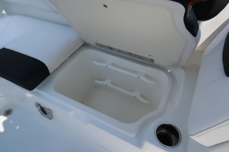 Slide: The Image of Open storage compartment on 2017 Tahoe 2150 boat with white seating and cup holder. - 14