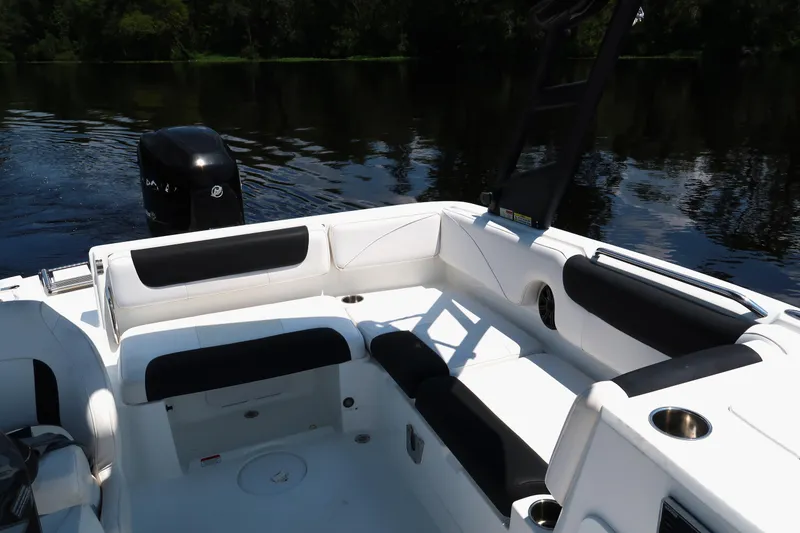 Slide: The Image of 2017 Tahoe 2150 boat interior with white and black seating on a calm lake. - 7