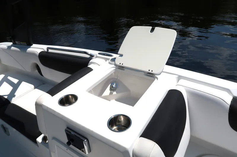 Slide: The Image of 2017 Tahoe 2150 boat interior with open storage compartment and cup holders. - 8