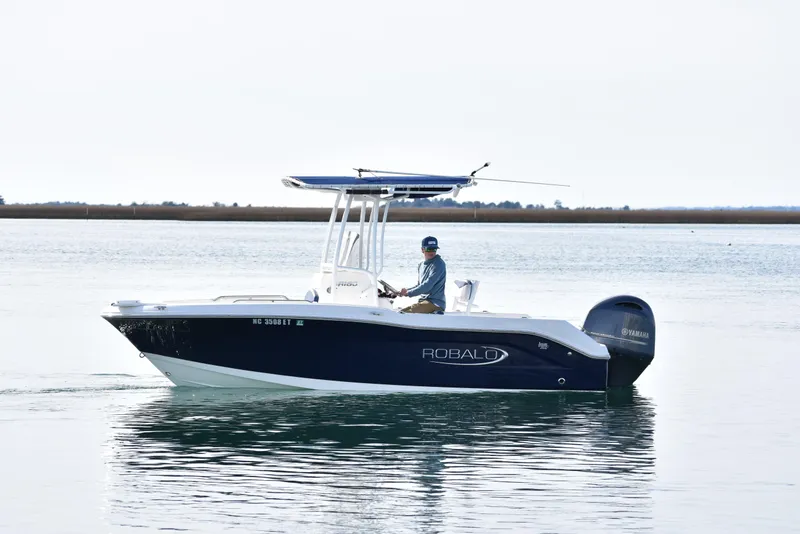 Slide: The Image of 2021 Robalo R180 Center Console boat on calm water, side view. - 3