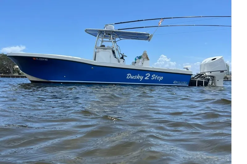 The Image of 2006 Dusky 278 Open Fisherman boat on water, blue hull, clear sky background. - 1