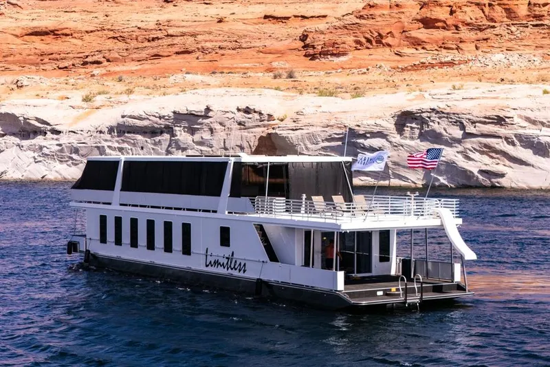 The Image of Luxurious 2026 Sumerset Luxe III houseboat cruising on scenic waters with rocky backdrop. - 1