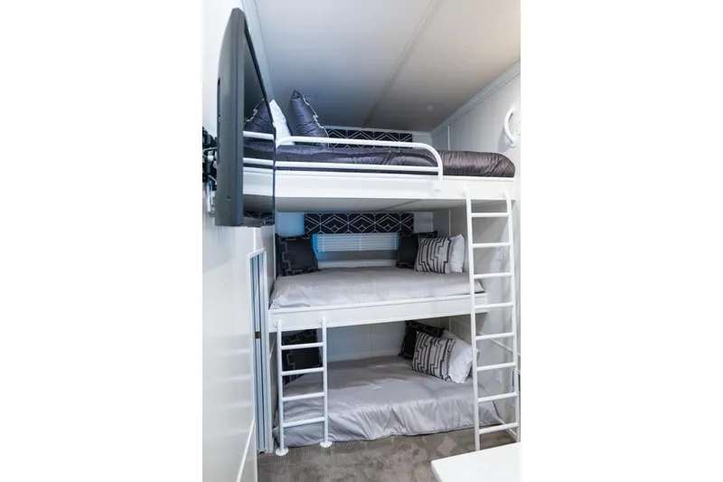 Slide: The Image of Triple bunk beds in Sumerset Luxe III 2026 houseboat, featuring modern design and cozy bedding. - 2