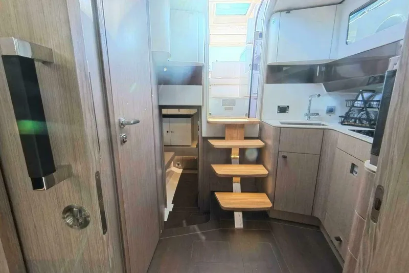 Slide: The Image of 2024 Fjord 41XP yacht interior with modern kitchen and wooden stairs. - 11