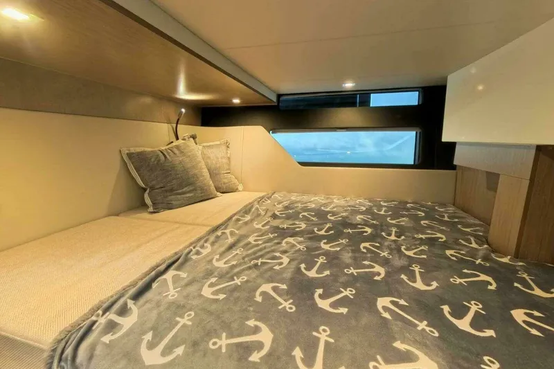 Slide: The Image of Cozy cabin interior of 2024 Fjord 41XP yacht with anchor-patterned bedding. - 14