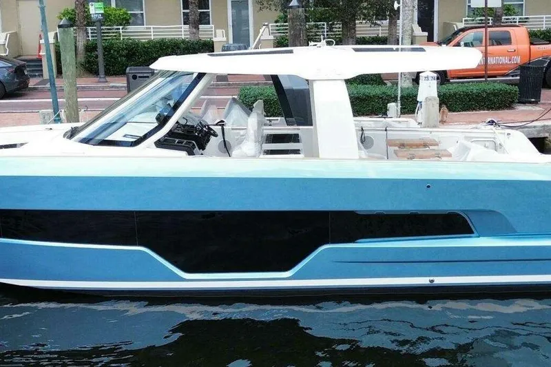 Slide: The Image of 2024 Fjord 41XP luxury yacht docked, featuring sleek blue and white design. - 2