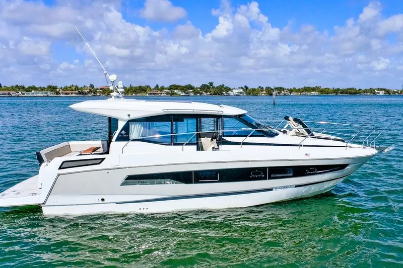 The Image of 2020 Jeanneau NC 37 yacht cruising on clear blue water under a partly cloudy sky. - 1