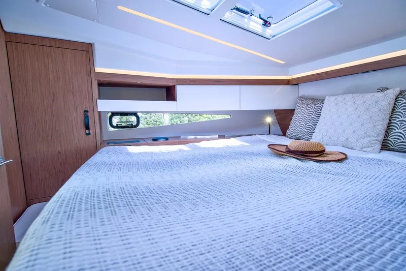 Slide: The Image of Luxurious cabin interior of 2020 Jeanneau NC 37 yacht with stylish bedding and natural light. - 23