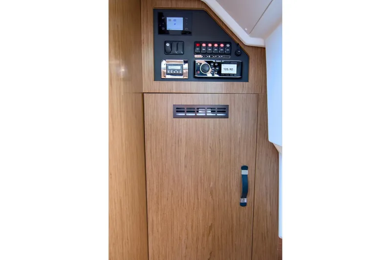 Slide: The Image of Control panel inside 2020 Jeanneau NC 37 boat, featuring wood finish and electronic controls. - 28