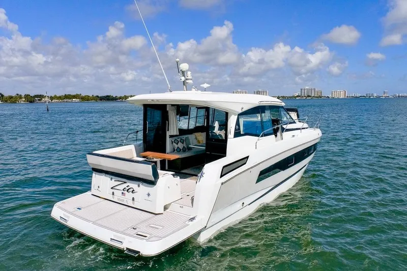 Slide: The Image of 2020 Jeanneau NC 37 yacht cruising on clear blue waters under a partly cloudy sky. - 3