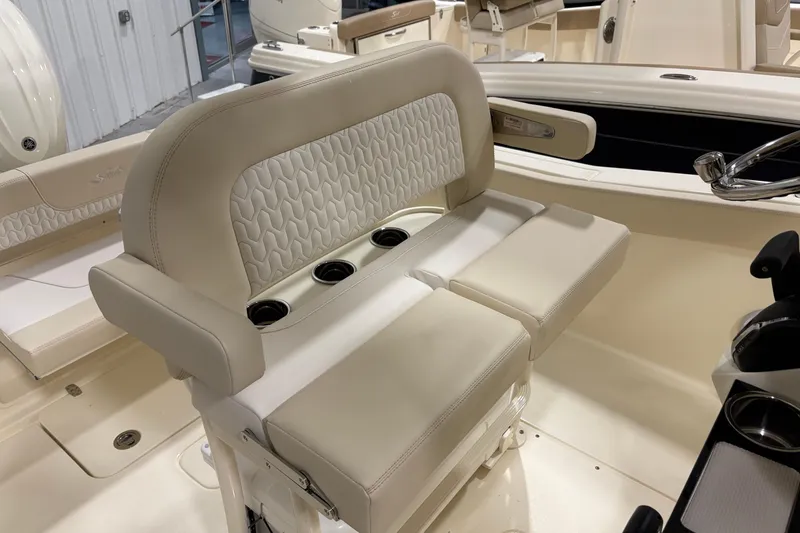 Slide: The Image of 2026 Scout 240 XSF boat interior with beige seating and cup holders. - 10