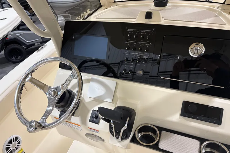 Slide: The Image of 2026 Scout 240 XSF boat dashboard with steering wheel and control panel. - 12