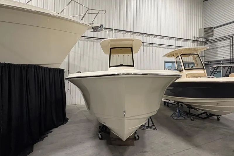Slide: The Image of 2026 Scout 240 XSF boat displayed in a showroom, showcasing sleek design and craftsmanship. - 2