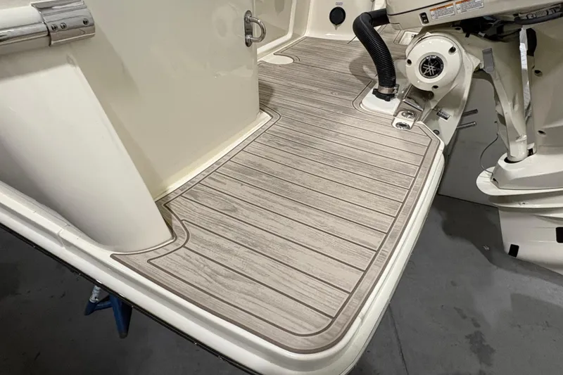 Slide: The Image of 2026 Scout 240 XSF boat deck with wood-like flooring and motor details. - 5