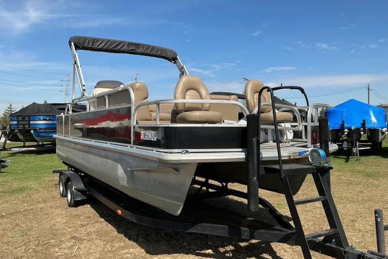 The Image of 2004 Voyager Pontoons 22 Super Fish & Cruise pontoon boat on trailer, parked outdoors. - 1