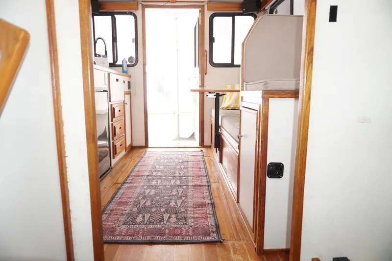 Slide: The Image of Interior of 1999 Eastern 31 Casco Bay boat with wooden cabinetry and patterned rug. - 13