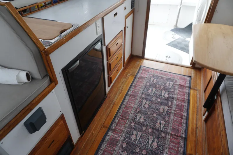 Slide: The Image of Interior of a 1999 Eastern 31 Casco Bay boat with wood flooring and compact kitchen area. - 6