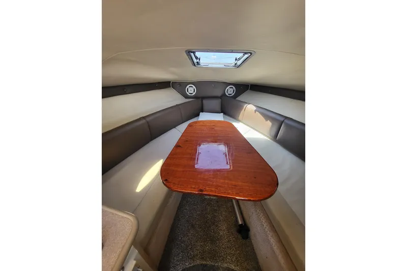 Slide: The Image of Interior cabin of 1999 Chaparral Signature 240 with wooden table and seating. - 2
