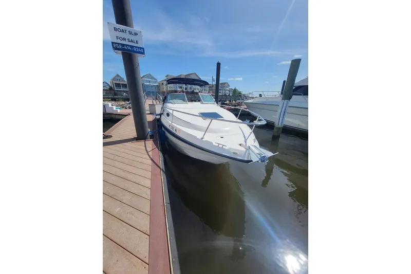 Slide: The Image of Chaparral Signature 240 boat docked at marina, 1999 model, sunny day, "Boat Slip For Sale" sign. - 3