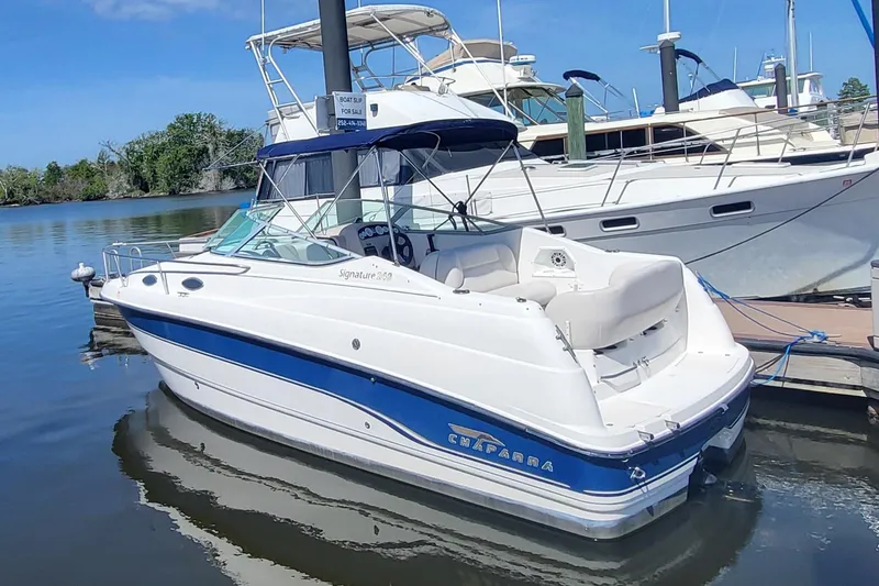 Slide: The Image of 1999 Chaparral Signature 240 boat docked at marina, featuring sleek design and blue accents. - 5