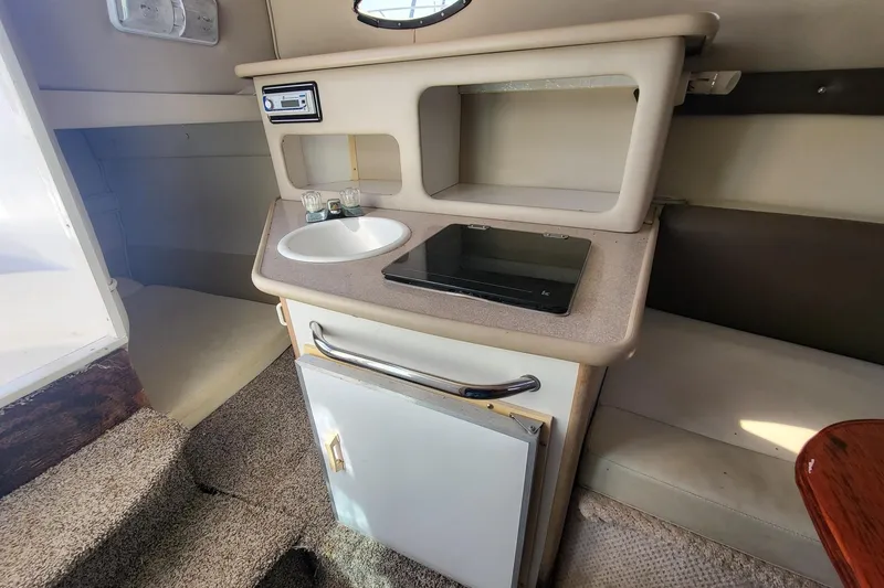 Slide: The Image of 1999 Chaparral Signature 240 cabin interior with sink, stove, and storage. - 6