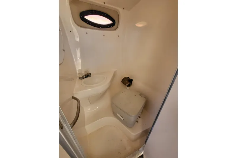 Slide: The Image of 1999 Chaparral Signature 240 boat bathroom interior with compact toilet and sink. - 8