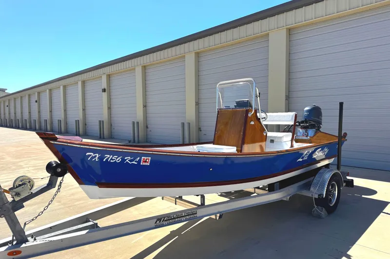 The Image of 2022 Farley Port A Skiff boat on trailer, parked near storage units. - 0