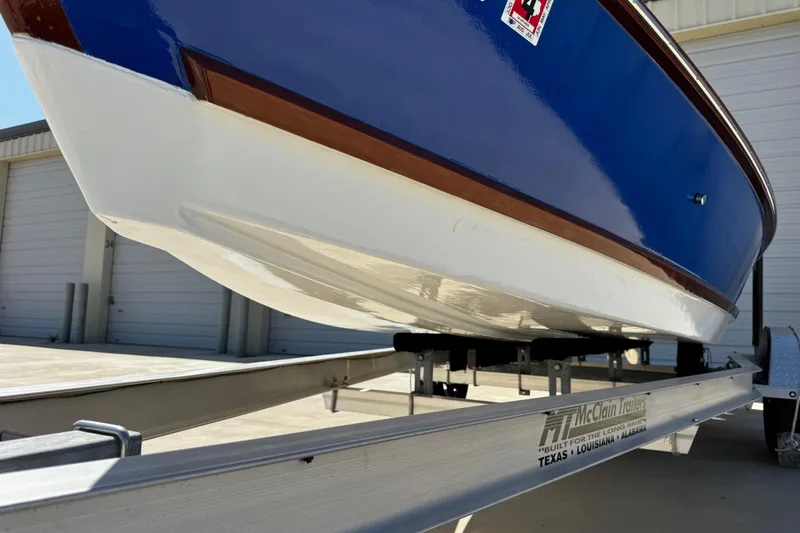 Slide: The Image of 2022 Farley Port A Skiff on trailer, blue and white hull, parked outside storage facility. - 11