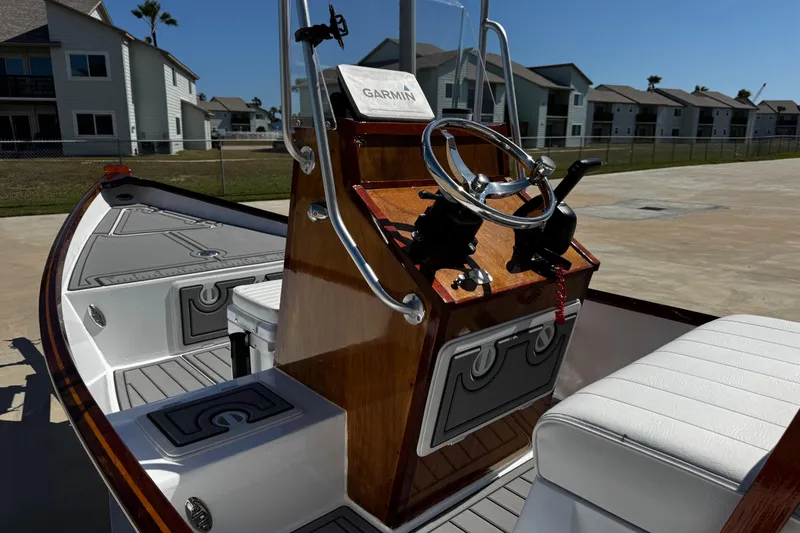 Slide: The Image of 2022 Farley Port A Skiff boat interior with steering console and seating, docked near residential area. - 14