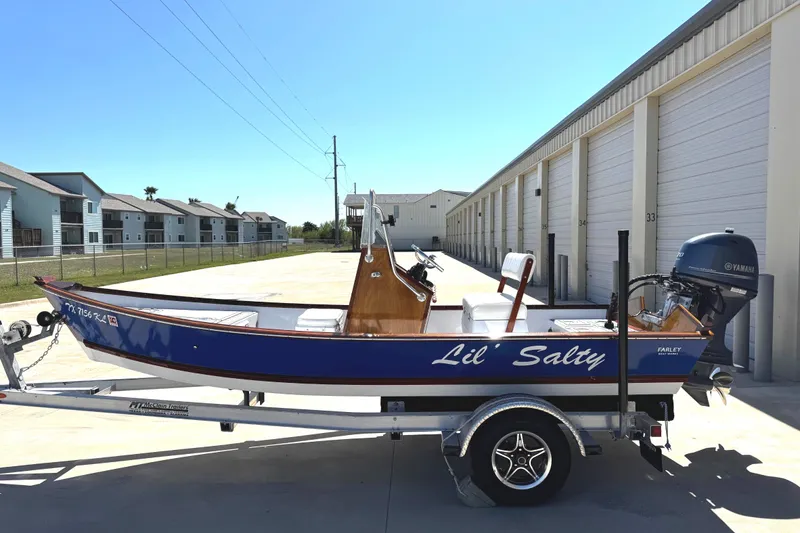 Slide: The Image of 2022 Farley Port A Skiff "Lil' Salty" on trailer, parked near storage units. - 3