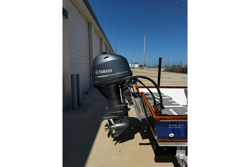 Slide: The Image of 2022 Farley Port A Skiff with Yamaha outboard motor, parked near a building. - 6