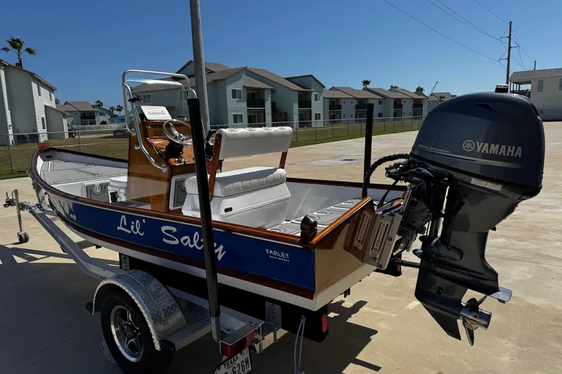 Slide: The Image of 2022 Farley Port A Skiff boat with Yamaha motor, parked on a trailer in a residential area. - 7