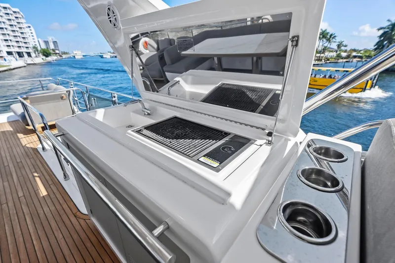 Slide: The Image of Outdoor kitchen on 2020 Azimut 66 yacht with grill and cup holders, docked by waterfront. - 16