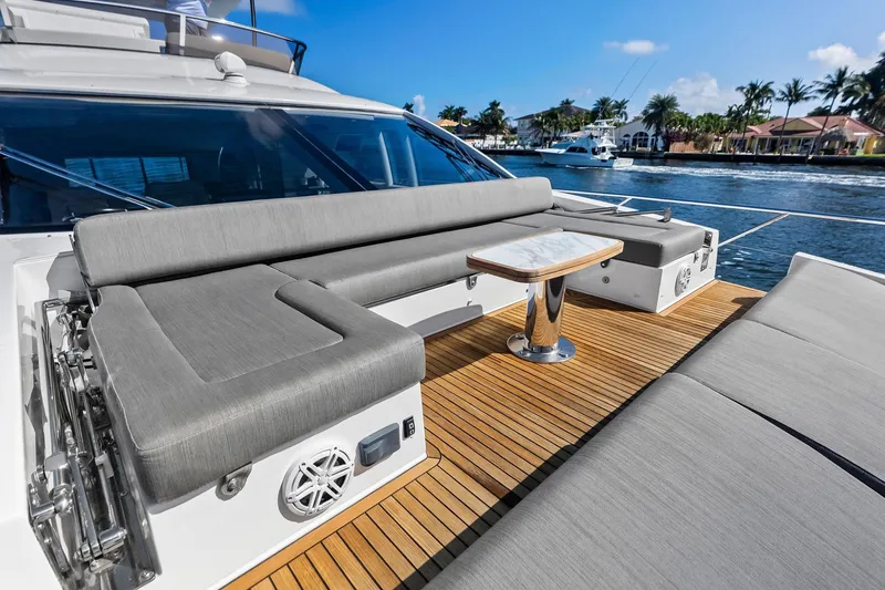 Slide: The Image of Luxurious 2020 Azimut 66 yacht deck with elegant seating and table, overlooking serene waterfront. - 18