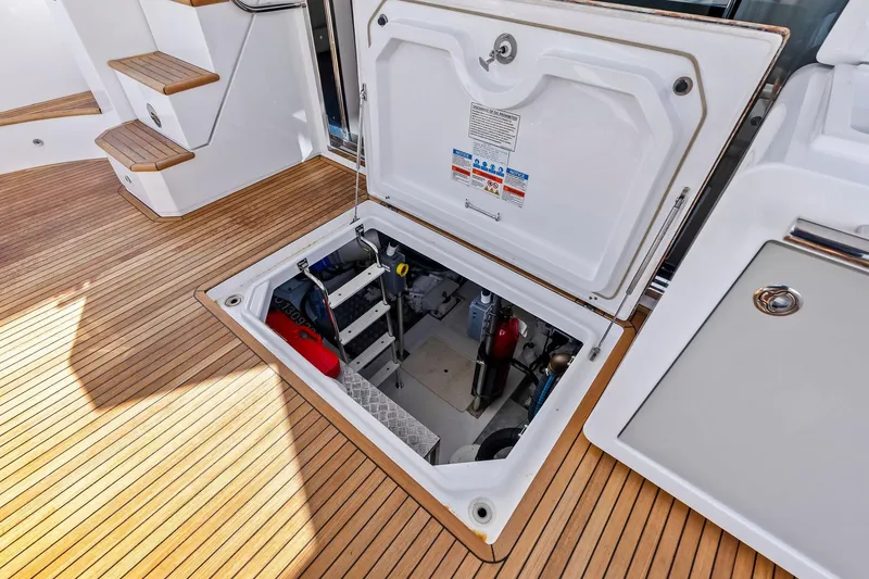 Slide: The Image of Open hatch on 2020 Azimut 66 yacht, revealing engine compartment on teak deck. - 49