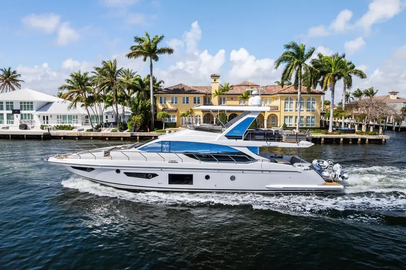 Slide: The Image of 2020 Azimut 66 yacht cruising near luxury waterfront homes and palm trees. - 59