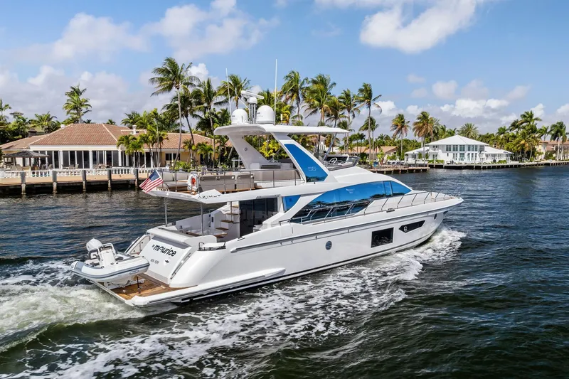 Slide: The Image of Luxury 2020 Azimut 66 yacht cruising near waterfront homes and palm trees. - 60