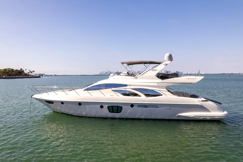 Slide: The Image of 2008 Azimut 62E yacht on calm water with city skyline in background. - 2